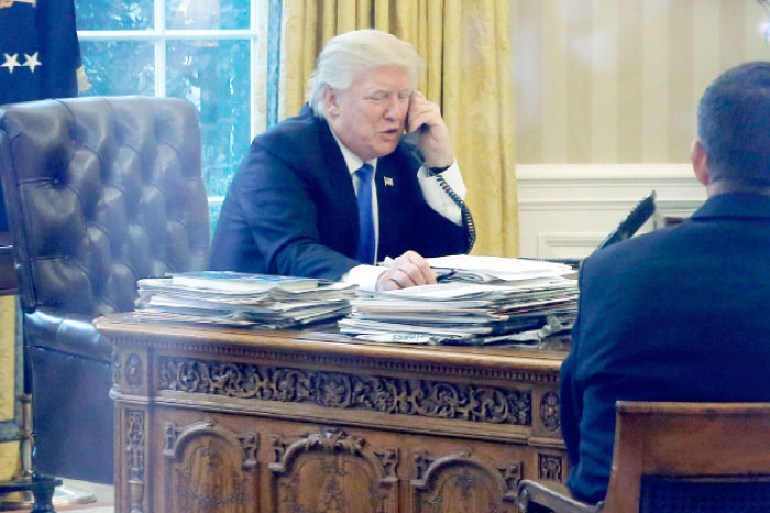 US President Donald Trump speaks by phone with Germany’s Chancellor Angela Merkel in the Oval Office at the White House in Washington on Saturday. — Reuters