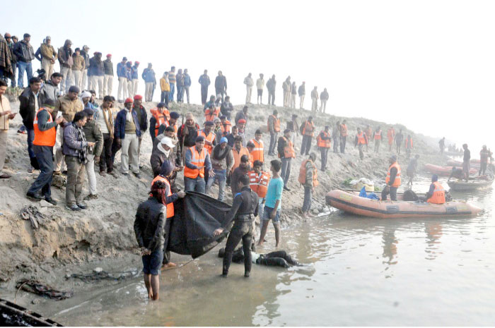 Indian rescue workers recover the body of a man who drowned in a boat accident on the river Ganges near Patna, Bihar, on Sunday. — AFP
