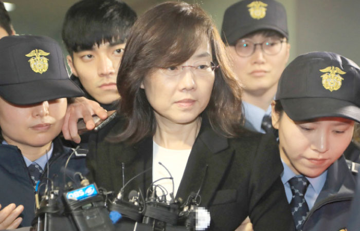 South Korea’s former Culture Minister Cho Yoon-Sun, center, is escorted by police following her arrest in Seoul on Saturday. — AFP