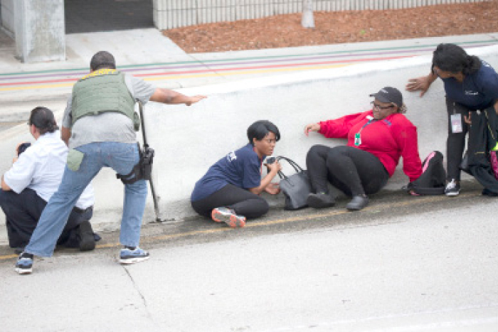 Law enforcement personnel tell people to take cover at Fort Lauderdale-Hollywood International Airport in Fort Lauderdale, Florida, on Friday. — AP