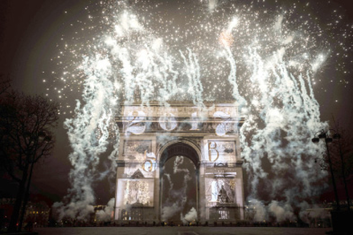 Fireworks explode over the Arc de Triomphe monument as part of New Year celebrations in Paris on Sunday. — AFP