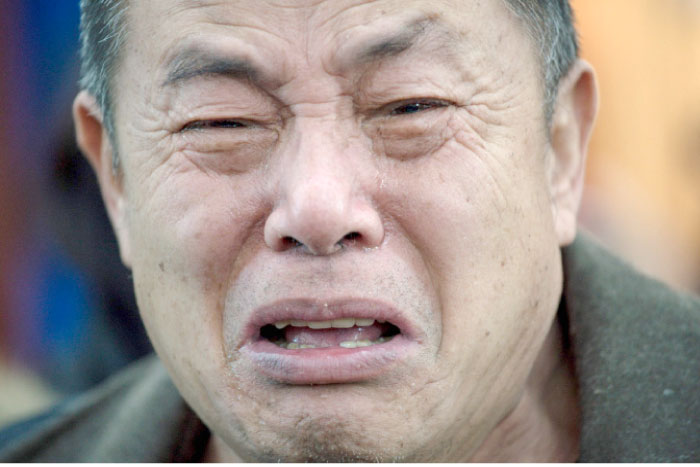 A relative of missing Chinese passengers aboard Malaysia Airlines Flight 370 that disappeared on March 8, 2014 cries before a meeting in Beijing on Wednesday, a day after authorities announced the end of search operations for the aircraft. — AFP