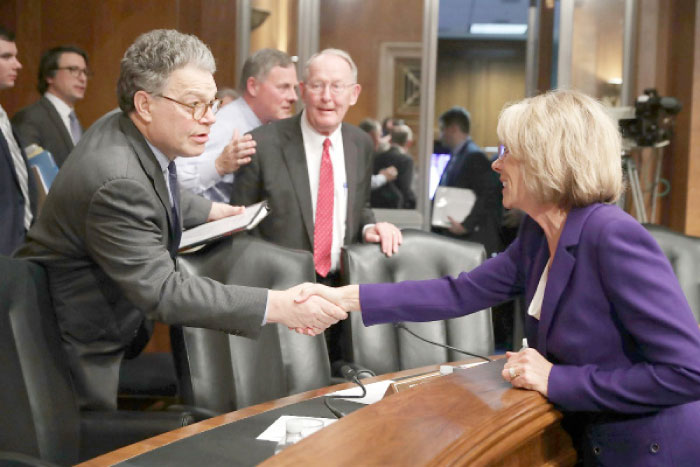 Senate Health, Education, Labor and Pensions Committee member Sen. Al Franken (D-MN), left, shakes hands with Betsy DeVos, President-elect Donald Trump’s pick to be the next Secretary of Education, with Sen. Michael Bennet after her confirmation hearing in the Dirksen Senate Office Building on Capitol Hill in Washington, D.C., on Tuesday. — AFP