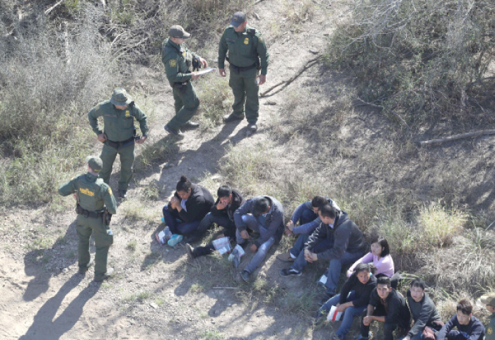US Border Patrol agents watch over immigrants who crossed the US-Mexico border near McAllen, Texas, on Tuesday. — AFP