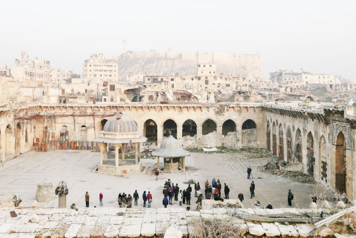 People visit the courtyard of the heavily damaged Great Mosque of Aleppo, overshadowed by a 13th century citadel, in the Old City of Aleppo, Syria. The mosque, also known as the Umayyad Mosque, a centuries-old treasure at the heart of one of the world’s oldest cities, is today a grim monument to the ravages of Syria’s war. — AP