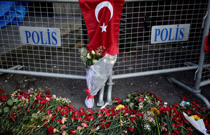 Flowers and a Turkish flag are placed near the entrance of Reina nightclub, which was attacked by a gunman, in Istanbul, Turkey Monday. — Reuters