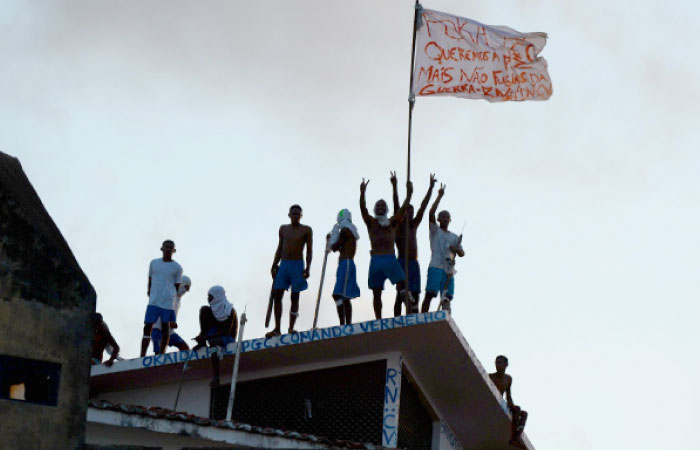 Prisoners atop the roof of the compound celebrate the transfer of their leaders after a negotiation with the police at the Alcacuz Penitentiary, near Natal, Rio Grande do Norte, Brazil, on Monday. — AFP
