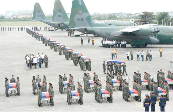 Philippine police commandos carry the flag-draped coffins of their fallen comrades from C-130 planes shortly after arriving at a military base in Manila in this Jan. 29, 2015 file photo. — AFP