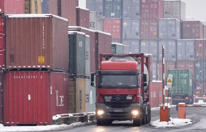 A  file photo shows trucks loaded with containers leave the harbor in Duisburg, Germany. — AP