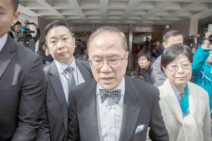 Hong Kong’s former chief executive Donald Tsang, center, leaves the High Court with his wife Selina Tsang, right, during the first day of his corruption trial in Hong Kong on Tuesday. — AFP