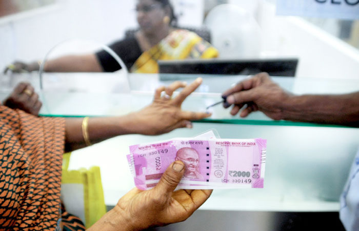 An Indian woman holds Rs2.000 notes as she has her finger marked with indelible ink after exchanging Rs500 and 1000 banknotes at a bank in Chennai in this Nov. 17, 2016 file photo. — AFP