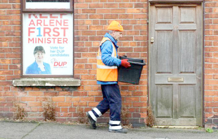 A worker walks past a poster of Democratic Unionist Party (DUP) leader and Outgoing Northern Ireland First Minister, Arlene Foster, near the party’s headquarters in Belfast in this Jan. 10, 2017 file photo. — AFP