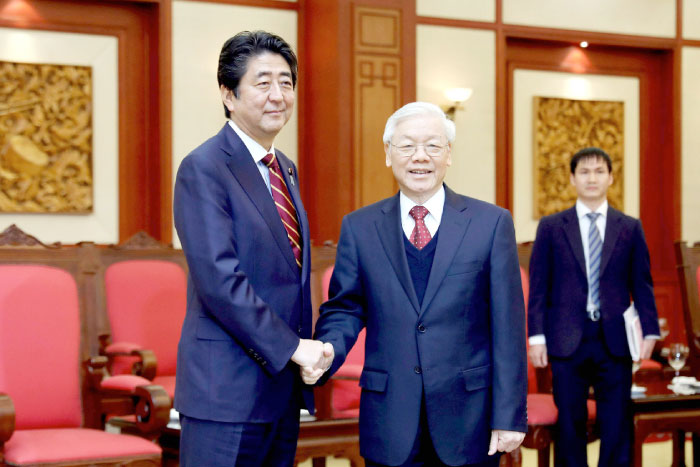 Vietnam’s General Secretary Nguyen Phu Trong shakes hands with Japan’s Prime Minister Shinzo Abe, left, at the office of the CPV Central Committee in Hanoi on Monday. — AFP
