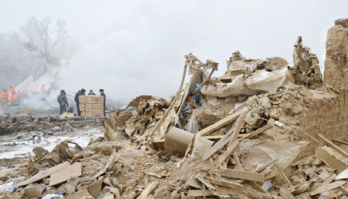 Rescue personnel work at the crash site of a Turkish cargo plane in the village of Dacha-Suu outside Bishkek on Monday. A Turkish cargo plane crashed into a village near Kyrgyzstan’s main airport Monday, killing at least 37 people and destroying houses after attempting to land in thick fog, authorities said. — AFP