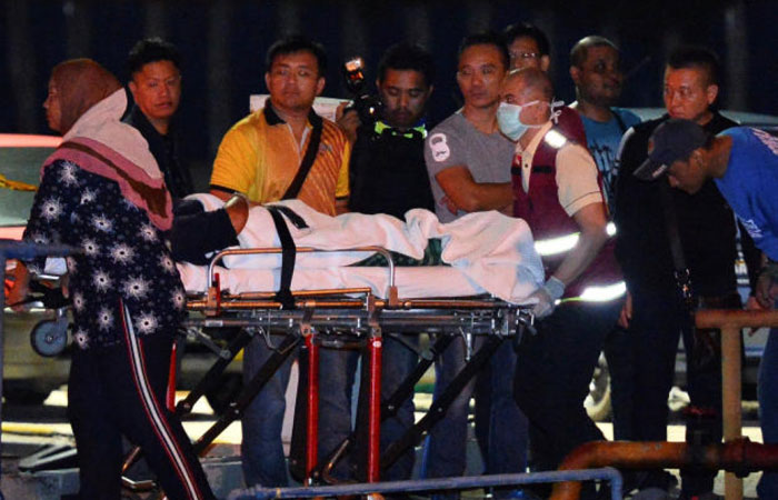 Police coast guards escort a Chinese tourist rescued after their boat sank off the coast of Borneo, at a port in Kota Kinabalu, Malaysia, on Monday. — Reuters