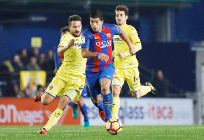 Villarreal’s defender Mario (L) vies with Barcelona’s Uruguayan forward Luis Suarez during their Spanish league football match at El Madrigal Stadium in Vilareal Sunday. — AFP