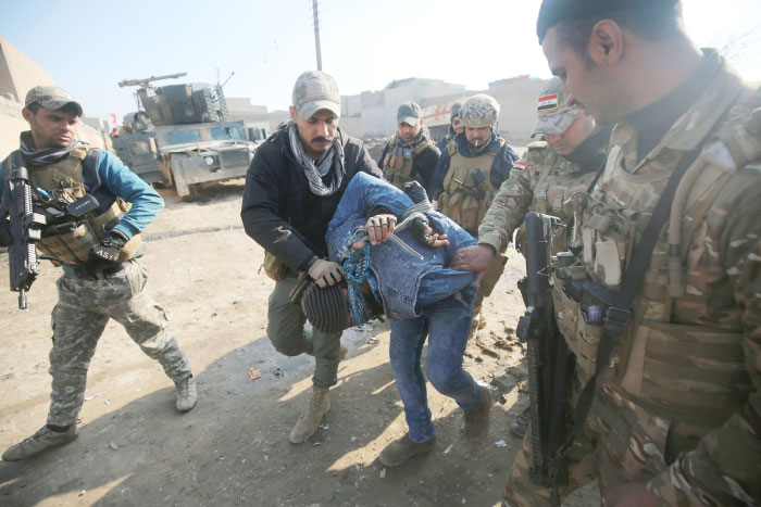 Iraqi forces detain a man suspected of belonging to the Daesh group in the Al-Intisar area in eastern Mosul after recapturing it in an ongoing military operation against the militants. — AFP