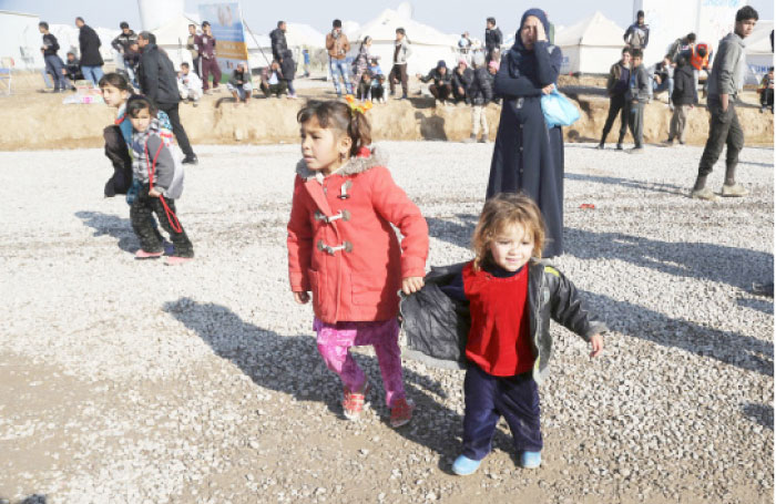 Displaced Iraqis, who fled fighting between Iraqi security forces and Daesh militants, prepare to leave Hassan Sham camp, east of Mosul, Iraq, Monday. — AP