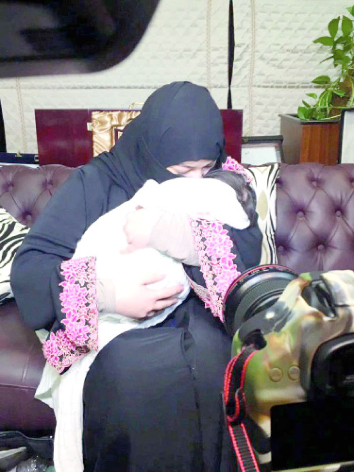 Nareman, a 23-year-old Syrian woman, hugs her four-month-old daughter Dareen, who has been rescued from an abusive father. — Okaz photo