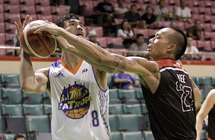 TNT’s Troy Rosario is handcuffed by Mahindra’s Mark Yee in their PBA Philippine Cup match at the Cuneta Astrodome on Wednesday night.