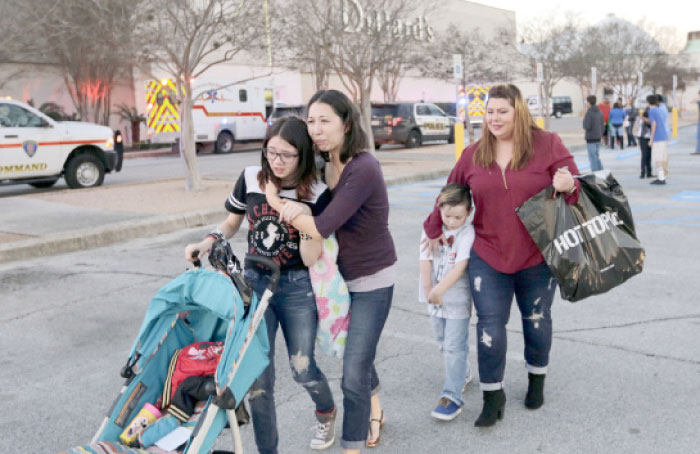 Shoppers with their children react after San Antonio police helped them exit the Rolling Oaks Mall after a deadly shooting in San Antonio, Texas, on Sunday. — AP