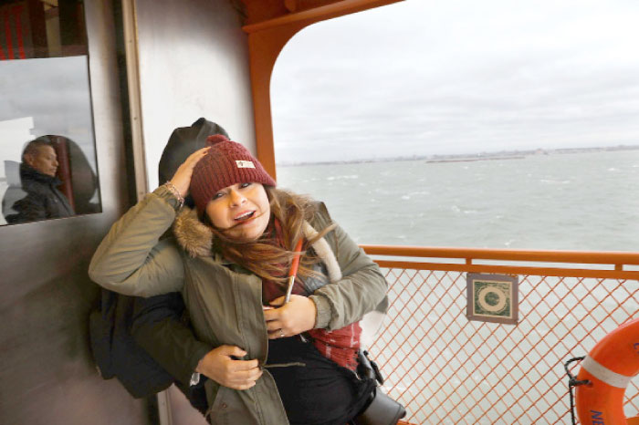 Passengers on the Staten Island Ferry struggle with the wind as New York City prepares for a nor’easter storm on in New York City on Monday. — AFP
