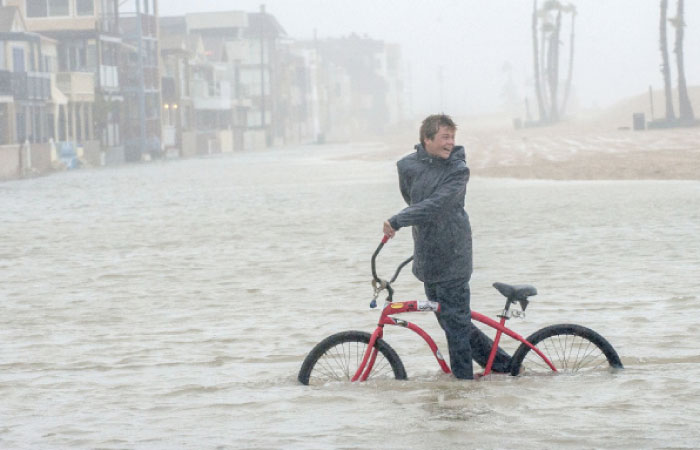 Jake Hart, 13, plays in the rising floodwater during a storm in Seal Beach, California, on Sunday. — AP