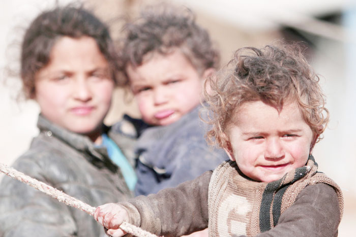 Internally displaced Syrian children who fled Raqqa city stand near their tent in Ras Al-Ain province, Syria. — Reuters