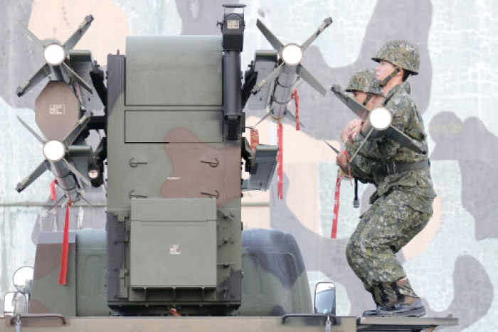 Taiwan soldiers load home-made Tien Chien surface-to-air missiles onto a launcher during an annual drill in Tainan on Tuesday. — AFP