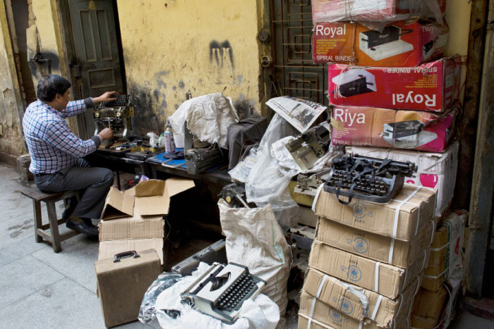 An Indian laborer repairs an old typewriter in New Delhi, India. — AP