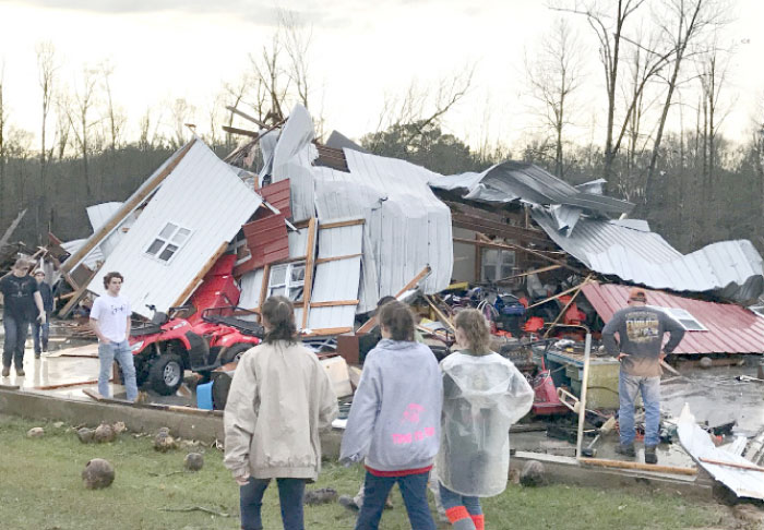 People examine a barn owned by the Miller family that was destroyed during a storm south of Mount Olive, Missouri, on Monday. — AP