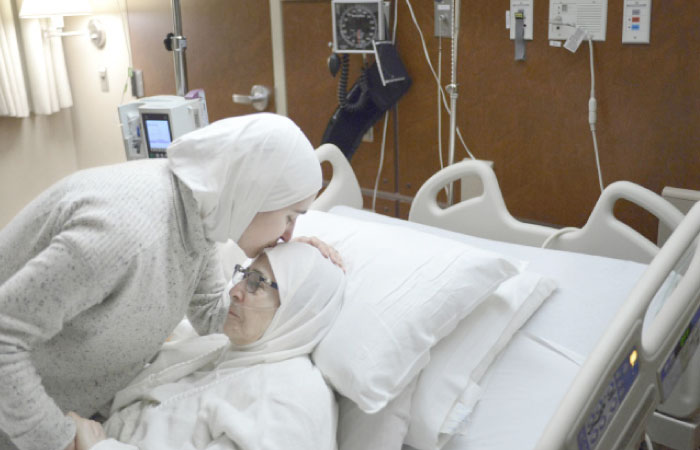 Nour Ulayyet left, comforts her mother Isaaf Jamal Eddin at Munster Community Hospital in Munster, Ind. Ulayyet of Valparaiso, Ind., said her sister, a Syrian living in Saudi Arabia who had a valid visa, was sent back after arriving from Riyadh at Chicago›s O›Hare International Airport on Saturday and told she couldn›t enter the US to help care for their sick mother following President Donald Trump›s executive order banning individuals from certain Muslim-majority countries from entering the US. — AP