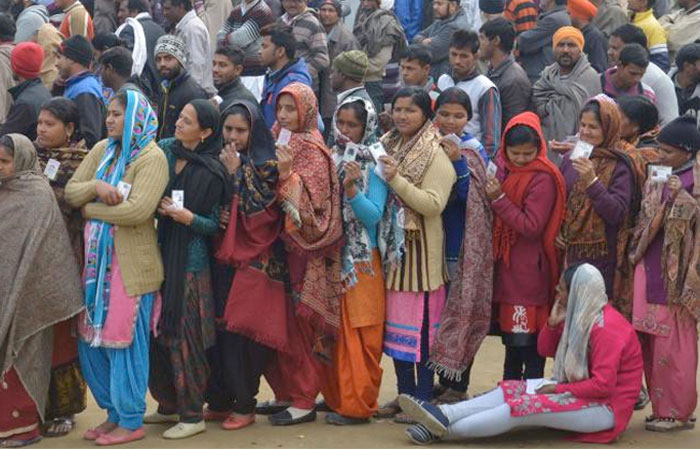 Indian voters pose for photographers as they queue to cast their ballots in the Punjab Legislative Assembly and Amritsar Lok Sabha elections at a polling booth in a village on the outskirts of Amritsar. — AFP