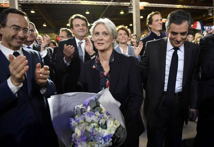 Penelope Fillion, center, flanked by her husband French right-wing candidate for the upcoming presidential election Francois Fillon, right, receives a bouquet upon her arrival at a campaign rally in Paris in this Jan. 29, 2017 file photo. — AFP