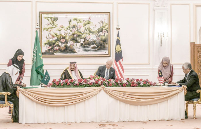 Custodian of the Two Holy Mosques King Salman and Malaysia’s Prime Minister Najib Razak oversee the signing of a memorandum of understanding between the Kingdom and Malaysia in Putrajaya, outside Kuala Lumpur, on Monday. Malaysia’s Minister of Higher Education Idris Jusoh (R) and Saudi Arabia’s Minister of Labor and Social Development Ali Al-Ghafis signed the documents. — AFP