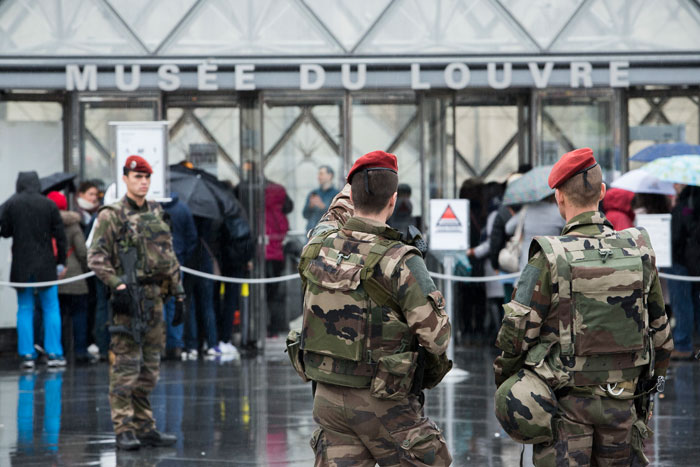 French soldiers patrol in the courtyard of the Louvre museum with the visitor control in background in Paris on Saturday. The Louvre in Paris reopened to the public Saturday morning. — AP