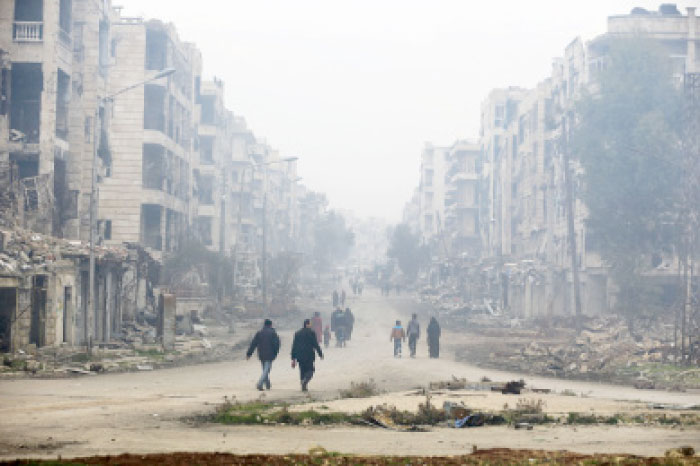 Residents walk through the destruction in the once rebel-held Salaheddine neighborhood of eastern Aleppo.