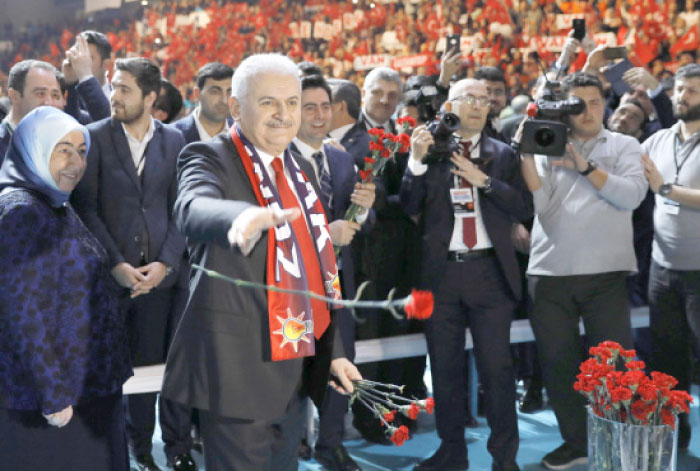 Turkish Prime Minister and leader of the ruling AK Party Binali Yildirim greets his supporters in Ankara on Saturday during a campaign meeting for the April 16 constitutional referendum. — Reuters