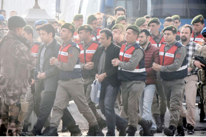 Paramilitary police escort the defendants as a trial opened in Mugla, southern Turkey for 47 people accused of attempting to kill President Recep Tayyip Erdogan on the night of the failed coup, while he was vacationing with his family. — AP