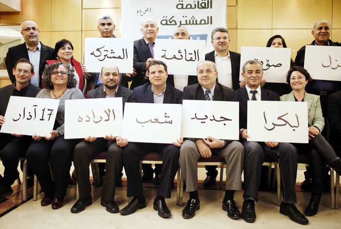 This file photo taken on Feb. 24, 2015, shows Arab Israeli political leaders (front row from L to R) Dov Khenin, Aida Tuma, Masud Ghanayem, Ayman Odeh, Ahmad Tibi, Jamal Zahalka and Hanin Zuabi posing for a photo holding placards bearing text in Arabic meaning “Go to vote for the joint list, for a new tomorrow on March 17” in the northern Israeli city of Nazareth. — AFP