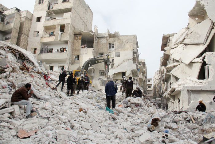 Syrian civil defense volunteers, known as the White Helmets, look for survivors amidst the debris following a government air strike on the Syrian town of Ariha, in the northwestern province of Idlib on Monday. — AFP