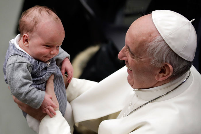 Pope Francis holds a baby during an audience with members of Entrepreneurs for Economy of Communion, at the Paul VI Hall, at the Vatican, on Saturday. — AP