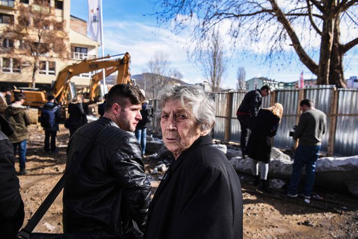 A Serbian woman looks on as bulldozers take down a concrete wall near the main bridge in the town of Mitrovica on Sunday, after the Kosovo government reached an agreement with country's ethnic Serb minority to resolve the issue of a contested wall symbolically dividing the city of Mitrovica. — AFP