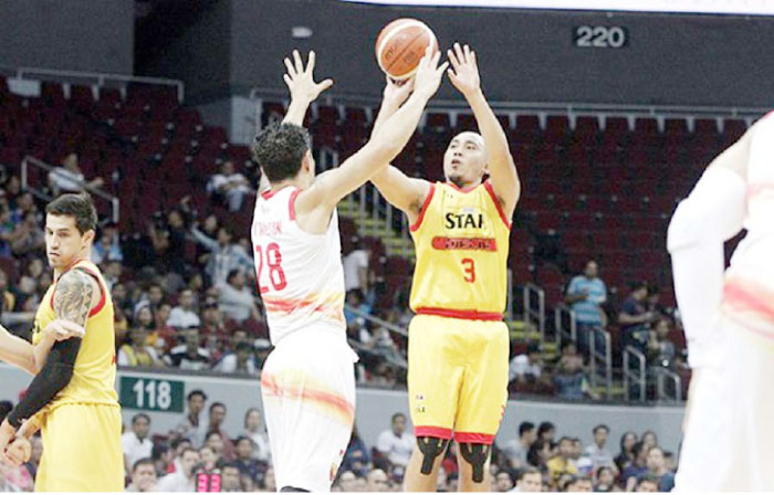 Star’s Paul Lee fires a shot off Phoenix’s Willy Wilson in Game 1 of their quarterfinals series at the Mall of Asia Arena on Saturday night.