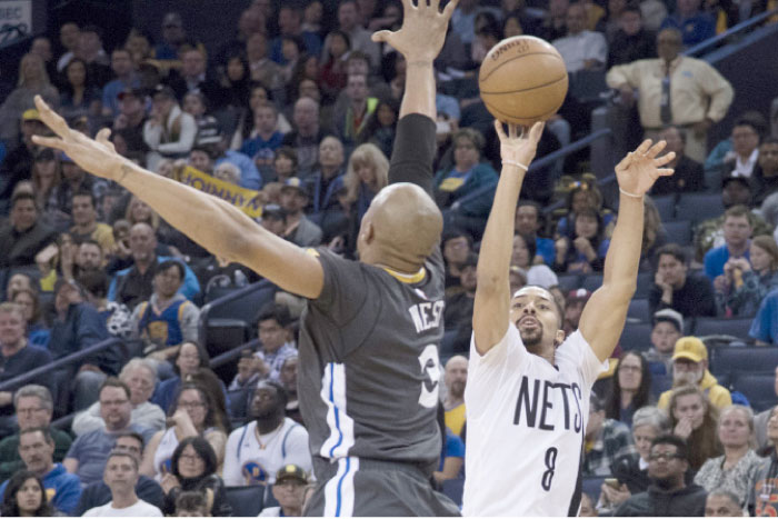 Brooklyn Nets’ guard Spencer Dinwiddie (R) shoots against Golden State Warriors’ forward David West during their NBA game at Oracle Arena in Oakland Saturday. — Reuters