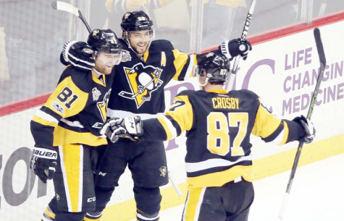 Pittsburgh Penguins’ right wing Phil Kessel (L) and defenseman Kris Letang (C) and center Sidney Crosby celebrate after Kessel scored a game-winning power play goal in overtime to defeat the Columbus Blue Jackets at the PPG PAINTS Arena in Pittsburgh Friday. — Reuters