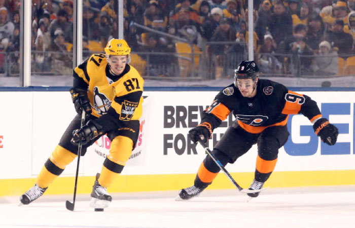 Pittsburgh Penguins’ center Sidney Crosby (L) handles the puck ahead of Philadelphia Flyers’ defenseman Ivan Provorov during their NHL game at Heinz Field in Pittsburgh Saturday. — Reuters