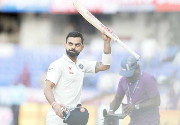 India’s captain Virat Kohli raises his bat to acknowledge the applause from the crowd at the end of play on first day of the Test match against Bangladesh in Hyderabad Thursday. — AP