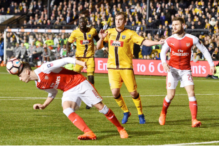 Arsenal’s English defender Rob Holding (L) gets his head to the ball during the English FA Cup fifth round football match between Sutton United and Arsenal at the Borough Sports Ground, Gander Green Lane in south London on Monday. — AFP