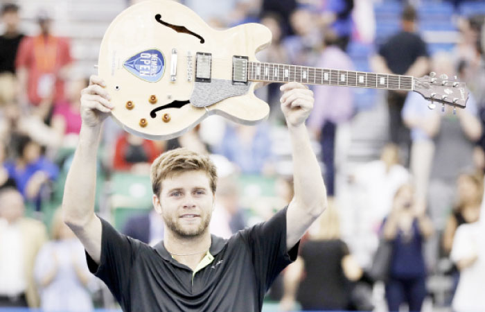 Ryan Harrison, of the United States, celebrates with his guitar trophy after defeating Nikoloz Basilashvili in the singles championship at the Memphis Open tennis tournament Sunday in Memphis, Tenn. — AP